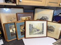 Group shot of seven framed artworks showing variety of images and frames