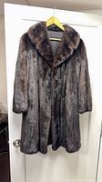 Front view of brown mink coat on hanger showing overall appearance and length
