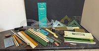 Overall view of fountain pen, slide rule, rulers, templates, stapler, pencils