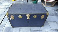 Front view of blue trunk with brass hardware