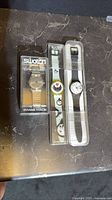 Three Swatch watches in cases side by side