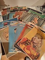 Group shot of assorted vintage Sunday News and Coloroto magazine issues spread on table