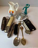 Entire assortment including knives, spoons, pitcher, coins, Gumby, key, cribbage