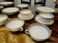 Detail of cups, saucers and two-handled soup bowls