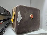 Brown Kodak projector case with red/yellow logo badge showing exterior wear