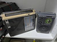 Front view of both radios on shelf showing grills, dials and antennas