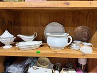 Shelf view showing all items including tureen, gravy boat, baking dishes, pie plates, aluminum molds
