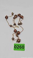 Full view of gold chain necklace with bronze beads