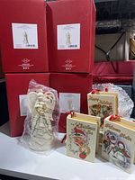 Group shot of four Lenox boxes, one unused angel ornament in plastic, three Mr. Christmas book ornaments and one wrapped book ornament