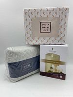 Group shot of South Street Loft sheet set, Home Reflections sheet set, and boxed Luminara candle