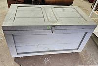 Closed view of painted wooden chest on casters