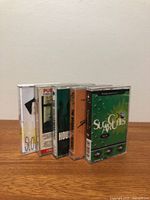 Five cassette tapes standing side by side showing spines