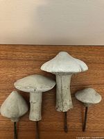 Front view of four concrete mushroom ornaments