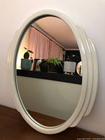 Front view of round mirror with white molded frame