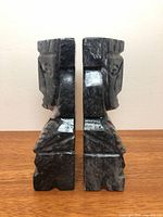 Side view of both grey stone bookends showing carved profiles and width