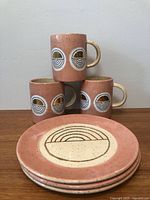Stack of four plates and four mugs showing overall set
