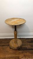 Full view of round pedestal table against wall