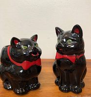 Front view of both black cat ceramic pieces