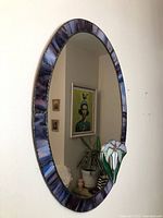 Full view of oval stained glass mirror mounted on wall