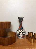 Teak bowls nested, ceramic vase, brass napkin rings grouped