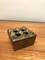 Top angle showing crater grid surface of brass ashtray