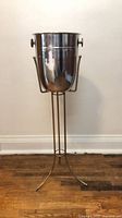 Full view of stainless steel bucket on brass stand