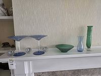 All seven glass pieces displayed on mantel
