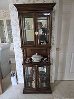 Full front view of the two-piece walnut curio cabinet