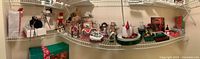 Shelf view of assorted Christmas figurines, tins, candle and boxed lights