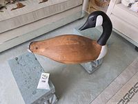 Side view of wooden Canada Goose decoy on display blocks