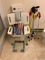 All items together: bath chair, therapy pillow box, masks, razor refills, reacher tongs, scale
