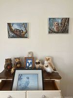 Group view showing framed artworks and owl figurines on dresser