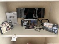 Shelf view showing Panasonic stereo, manual and CDs