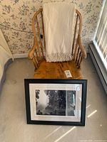 Chair front with blanket draped and framed photo leaning