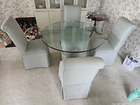 Full view of glass-top table with upholstered pedestal base