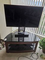 Front view of Samsung TV on corner stand with Blu-ray player