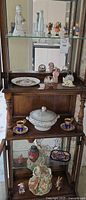 Cabinet view showing tureen, cups, saucers, dish, jars, figurines
