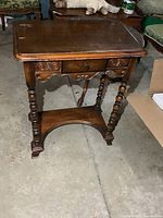 Front view of solid wood hall table showing drawer, turned legs and stretcher shelf