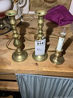 Front view of pair of brass candlesticks and electric candle lamp