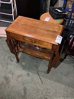 overall front view of solid wood end table showing drawer, lower shelf, turned legs