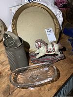 Group shot of all four items: oval frame, metal grater, glass dish, resin rocking horse