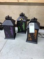 Three Halloween lanterns with colored panels on table