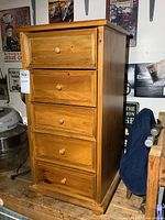 Front view of solid pine five-drawer lingerie chest showing all drawers with knobs