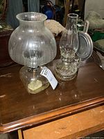 Both glass oil lamps side by side on table