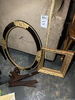 Oval and rectangular frames with easel pieces on floor