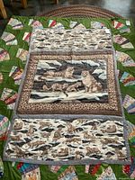 Full view of quilted crib topper on surface