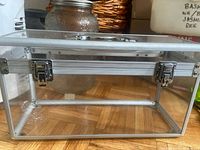 Front view of clear acrylic case showing aluminum frame and dual latches