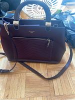 Front view showing color, chevron quilting, front zip pocket, top handles, crossbody strap