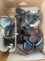 Box containing VR controllers, headset parts, stand, adapters and cables