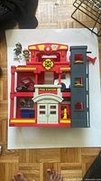 Overall view of Fisher-Price fire station playset, two action figures, hydrant accessory